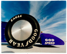 Load image into Gallery viewer, Photograph by Richard Heeps. This photograph has the tyre and the very front tip of a drag car. The car&#39;s name is written on the front end &quot;God Speed&quot;. Behind the car are white vertical clouds shooting through a blue sky.