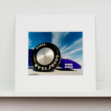Load image into Gallery viewer, Mounted photograph by Richard Heeps. This photograph has the tyre and the very front tip of a drag car. The car&#39;s name is written on the front end &quot;God Speed&quot;. Behind the car are white vertical clouds shooting through a blue sky.