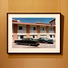 Load image into Gallery viewer, Black framed photograph by Richard Heeps. Hanging on the wall, this retro photograph has two classic Lincoln cars parked outside a hotel in Las Vegas. 