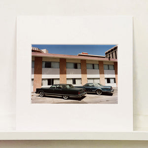 Mounted photograph by Richard Heeps. This retro photograph has two classic Lincoln cars parked outside a hotel in Las Vegas. 