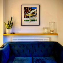 Load image into Gallery viewer, Black framed photograph in situ by Richard Heeps. A cream chair sits on hard standing, behind the chair and slightly out of focus is lush green grass and warm red tree trunks.