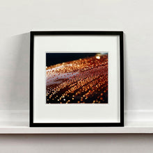 Load image into Gallery viewer, Black framed photograph by Richard Heeps. The photograph is of a brown metal surface with water droplets on. The lighting makes the droplets appear in different colours of orange and brown.