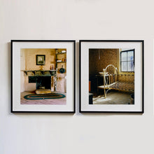 Load image into Gallery viewer, Black framed photographs by Richard Heeps. The first is from the Film set of &#39;The Outlaw Josey Wales&#39; featuring a wooden fireplace and a black and white photo over the mantlepiece. The second photograph is of a bedroom in an abandoned town featuring a bed frame, stand and wash basin.
