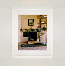 Load image into Gallery viewer, White framed photograph by Richard Heeps. Film set of &#39;The Outlaw Josey Wales&#39; featuring a wooden fireplace and a black and white photo over the mantlepiece.