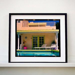 Black framed photograph by Richard Heeps. Palm Springs Pool Side II showcases classic mid-century Palm Springs California architecture. Cool blue skies and pool with accents of pink and almost neon yellow. 