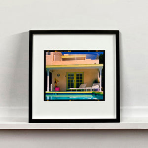 Black framed photograph by Richard Heeps. Palm Springs Pool Side II showcases classic mid-century Palm Springs California architecture. Cool blue skies and pool with accents of pink and almost neon yellow. 