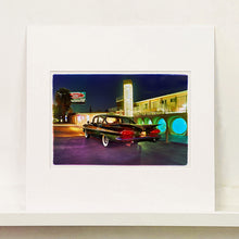 Load image into Gallery viewer, Mounted photograph by Richard Heeps. A Chevy Bel Air is central shot and off to the right are the pools and balcony of the Glass Pool Motel, Las Vegas.