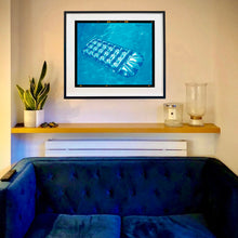 Load image into Gallery viewer, In situ photograph by Richard Heeps. A transparent blue lilo is sun bathing on a blue pool. 