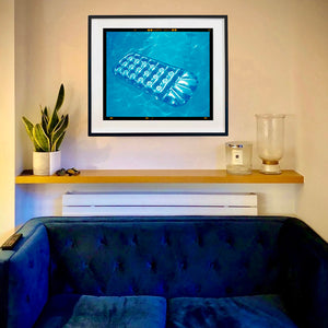 In situ photograph by Richard Heeps. A transparent blue lilo is sun bathing on a blue pool. 