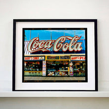 Load image into Gallery viewer, Black framed photograph by Richard Heeps. Harry&#39;s Corner was taken on the wildwood boardwalk, featuring neon typography and the iconic Coca-Cola sign against a bright blue sky. 