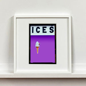 White framed photograph by Richard Heeps.  At the top black letters spell out ICES and below is depicted a 99 icecream cone sitting left of centre against a lilac coloured background.  