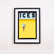 Load image into Gallery viewer, Black framed photograph by Richard Heeps.  At the top black letters spell out ICES and below is depicted a 99 icecream cone sitting left of centre against a sherbert yellow coloured background.  