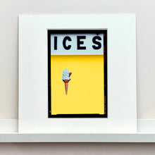 Load image into Gallery viewer, Mounted photograph by Richard Heeps.  At the top black letters spell out ICES and below is depicted a 99 icecream cone sitting left of centre against a sherbert yellow coloured background.  