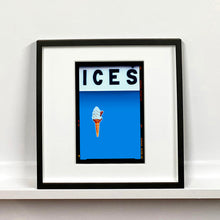 Load image into Gallery viewer, Black framed photograph by Richard Heeps.  At the top black letters spell out ICES and below is depicted a 99 icecream cone sitting left of centre against a sky blue coloured background.  
