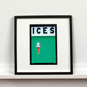 Black framed photograph by Richard Heeps.  At the top black letters spell out ICES and below is depicted a 99 icecream cone sitting left of centre against a viridian green coloured background.  