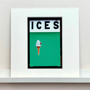 Mounted photograph by Richard Heeps.  At the top black letters spell out ICES and below is depicted a 99 icecream cone sitting left of centre against a viridian green coloured background.  
