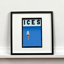 Load image into Gallery viewer, Black framed photograph by Richard Heeps.  At the top black letters spell out ICES and below is depicted a 99 icecream cone sitting left of centre against a baby blue coloured background.  