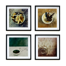 Load image into Gallery viewer, Four black framed photographs by Richard Heeps hung in a square. The first photograph is a bucket with sponges, brushes and wooden handled tools sitting in it on a cracked cement floor. The second one is of a selection of wooden handled knives sitting in a white container, the third photograph is a small white rice bowl with a green inside, sitting on a white table with a green wall behind. The fourth photograph is a metal hubcap, sitting against a faded brown flowered curtain.