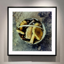 Load image into Gallery viewer, Black framed photograph by Richard Heeps. A bucket with sponges, brushes and wooden handled tools sit in a bucket on a cracked cement floor.