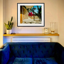 Load image into Gallery viewer, Black framed photograph by photographer, Richard Heeps. In situ photograph which is of a flowering bougainvillea hanging outside a motel entrance.