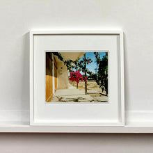 Load image into Gallery viewer, White framed photograph by Richard Heeps. A flowering bougainvillea hangs outside a motel entrance.