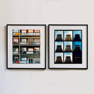 Two black framed photographs by Richard Heeps. The one on the left is the balconies and balcony doors of 4 floors of flats located on the Rue Dezza. The colours of the walls alternate between red and grey but look different as the light catches them. On the right hand side is 9 photos together of a building moving from daylight through to night light.