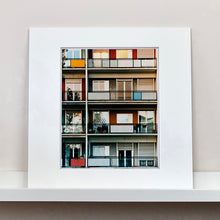 Load image into Gallery viewer, Mounted photograph by Richard Heeps. This is the balconies and balcony doors of 4 floors of flats located on the Rue Dezza. The colours of the walls alternate between red and grey but look different as the light catches them.