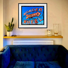 Load image into Gallery viewer, Framed artwork of &#39;Wonder Wheel&#39; on a wall above a blue sofa artwork by Richard Heeps
