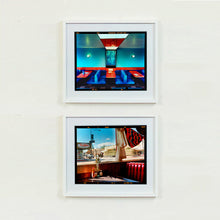 Load image into Gallery viewer, Two white framed photographs by Richard Heeps. The top photograph is of the inside of a Wimpy restaurant. Blue upholstered double seats pinned to the floor and separated by striking red tables. The walls are blue with a blue picture of trees with a black surround aligned with the middle table. The bottom photograph is of the inside of an American diner, with its iconic red upholstered seating, and looking out of the window.