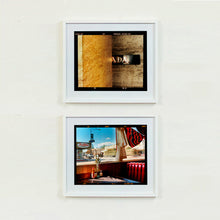 Load image into Gallery viewer, White framed photographs by Richard Heeps. The top photograph shows brown flecked marble walls in different tones. In the middle is half a brown plaque with golden letters showing half an A, followed by a D and an A. The bottom photograph is inside an American diner, with red seats, looking out towards a small town with a big blue sky.