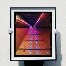 Load image into Gallery viewer, Black framed photograph held by the artist Richard Heeps. Stained glass windows on the interior of San Giovanni Bono Church, a concrete brutalist building in Milan by Italian architect Arrigo Arrighetti. 