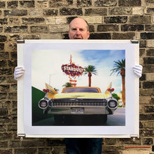 Load image into Gallery viewer, Photograph held by photographer Richard Heeps.  The back end of the classic American car with a number place DREAM01 sits underneath the STARDUST casino sign.