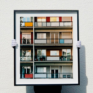 Photograph held by photographer Richard Heeps. This is the balconies and balcony doors of 4 floors of flats located on the Rue Dezza. The colours of the walls alternate between red and grey but look different as the light catches them.