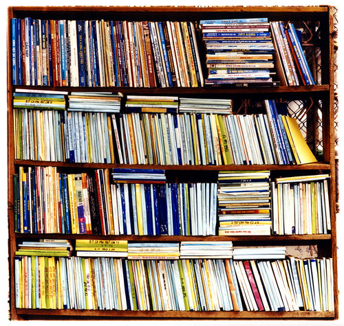Multi-color books in a book case square photograph