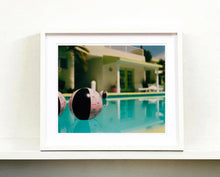 Load image into Gallery viewer, Part of Richard Heeps&#39; &#39;Dream in Colour&#39; Series, &#39;Beach Ball&#39; captures Palm Springs mid-century modern architecture behind a trio of pink and black beach balls. The stillness and the subtle colours combine to make a calming artwork with a seductive cinematic vibe.
