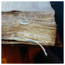 Load image into Gallery viewer, Photograph by Richard Heeps.  A close up of a corner of an old, worn, battered, academic book.