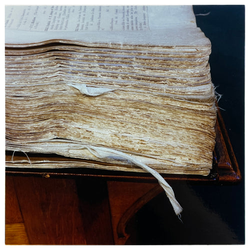 Photograph by Richard Heeps.  A close up of a corner of an old, worn, battered, academic book.