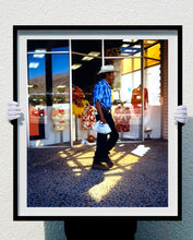 Load image into Gallery viewer, &#39;Boutique&#39; is street portrait, taken in Palm Springs, California. This piece is different from Richard Heeps&#39; usual style, but everything fell into place: the light, the colours, and the man walking through the shot.