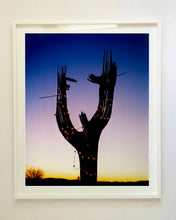 Load image into Gallery viewer, The silhouette of a large scale cactus, dressed in twinkle lights, set against an ombre twilight sky. Photographed by Richard Heeps in the Arizona desert, for his &#39;Dream in Colour&#39; series.