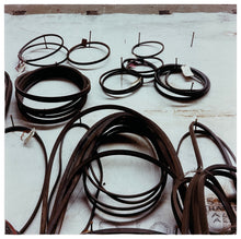 Load image into Gallery viewer, Photograph by Richard Heeps. A selection of different size drive belts hang on a set of nails. 