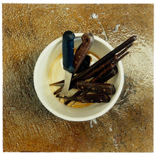 Load image into Gallery viewer, Photograph by Richard Heeps. A pot of filleters knives sits in the middle of a brown-mottled glass work surface. 
