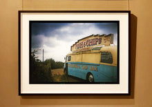 Load image into Gallery viewer, A moody Fenland sky is backdrop to a classic British Fish &amp; Chips Van. The typography and the van itself has a fun fairground feel, contrary to the muted tones of this piece. Part of Richard Heeps series, &#39;A View of the Fens from the Car with Wings&#39;.