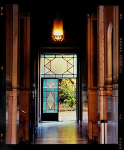 An Art Deco entrance hall in Milan, featuring blue stained glass panelling and marble flooring.
