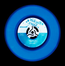 Load image into Gallery viewer, Photograph by Natasha Heidler and Richard Heeps.  A denim blue record with darker blue grooves and the record label is half white, half blue with writing in the opposite blue and white.  This vinyl sits on a black background.