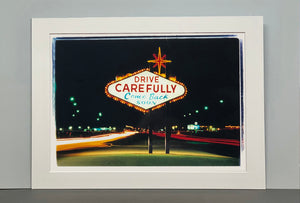 Taken upon leaving Las Vegas, and featured in Richard Heeps' 'Dream in Colour' series, this piece features a classic American neon sign, with the Las Vegas lights disappearing into the distance. 