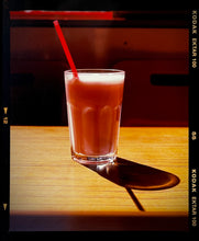 Load image into Gallery viewer, This enticing pink milkshake in a glistening glass was photographed by Richard Heeps in a Clacton-on-Sea cafe. The composition of this artwork is beautifully balanced by the angles of the red straw and shadow. 