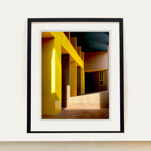 Load image into Gallery viewer, Monte Amiata housing, Gallaratese Quarter, Milan. Yellow brutalist architecture street photography by Richard Heeps framed in black.