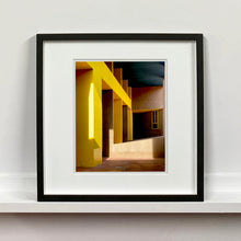 Load image into Gallery viewer, Monte Amiata housing, Gallaratese Quarter, Milan. Yellow brutalist architecture street photography by Richard Heeps framed in black.