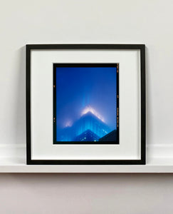 'NOMAD II (Film Rebate)', New York. Richard Heeps has photographed the iconic Empire State building in the mist. The NOMAD sequence of photographs capture the art deco architecture illuminated by changing colours, and is part of Richard's street photography portfolio which depict the colour, fabric and structure of cities with distinct style. This 6x7 format edition is bordered by the Kodak film rebate. 