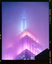 Load image into Gallery viewer, &#39;NOMAD VIII (Film Rebate)&#39;, New York. Richard Heeps has photographed the iconic Empire State building in the mist. The NOMAD sequence of photographs capture the art deco architecture illuminated by changing colours, and is part of Richard&#39;s street photography portfolio which depict the colour, fabric and structure of cities with distinct style. This 6x7 format edition is bordered by the Kodak film rebate. 